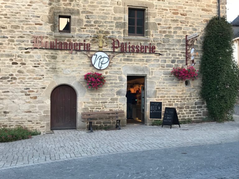 Façade en pierre de la Boulangerie du Patrimoine à Noyal-Muzillac avec enseigne et fleurs